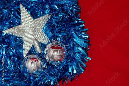 Fondo rojo navideño con espumillón azul y estrella de navidad plateada. photo