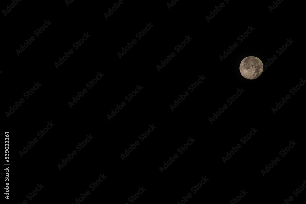 Full moon in the night sky. Full Ominous moon against the background of a completely dark black night without a starry sky. Place for text. Copy space. Devil Moon. Deep space. Heavenly nature. Full moon in the night sky. Full Ominous moon against the background of a completely dark black night without a starry sky. Place for text. Copy space. Devil Moon. Deep space. Heavenly nature.