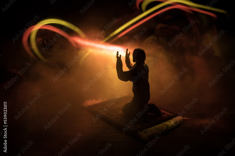 Silhouette of mosque building on toned foggy background. Ramadan Kareem background. Mosque at sunset. Praying people