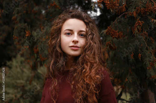 Curly red haired girl in autum park