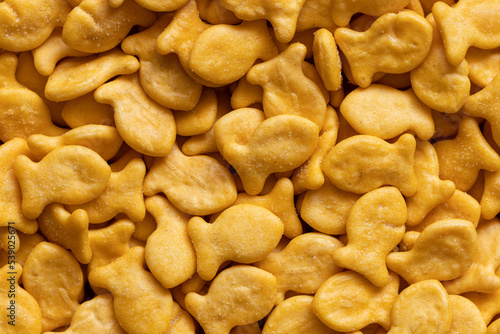 Goldfish cookies background. Top view of fish-shaped salted crackers. Small biscuits.