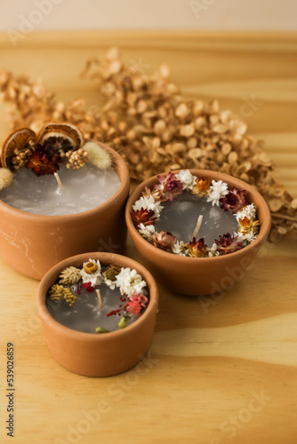 handmade aromatic candles with dried flowers above and on the side