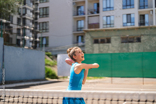 Sportive young girl with racquet playing padel in the open court outdoors