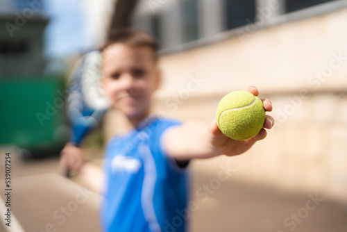 Sportive young boy with racquet playing padel in the open court outdoors © diignat