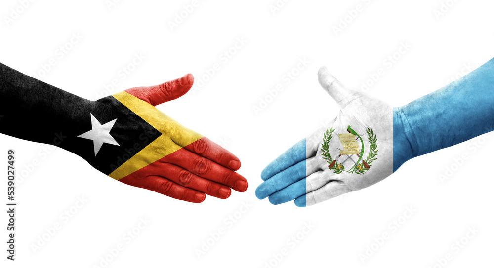 Handshake between Guatemala and Timor Leste flags painted on hands, isolated transparent image. Handshake between Guatemala and Timor Leste flags painted on hands, isolated transparent image.
