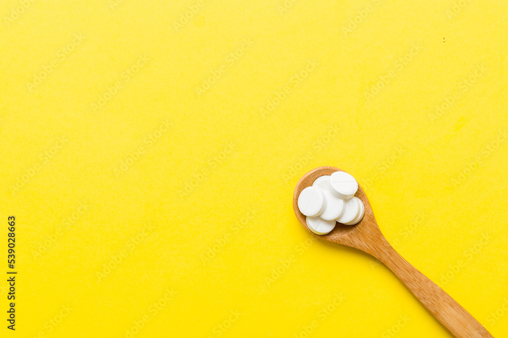 Heap of white pills on colored background. Tablets scattered on a table. Pile of red soft gelatin capsule. Vitamins and dietary supplements concept Heap of white pills on colored background. Tablets scattered on a table. Pile of red soft gelatin capsule. Vitamins and dietary supplements concept