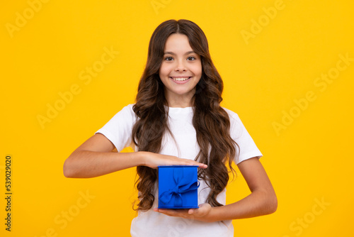 Teenager kid with present box. Teen child girl giving birthday gift. Present, greeting and gifting concept.