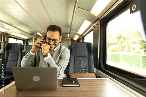 Young business man traveling to work by train, working while traveling, with his laptop and notebook, talking on phone, writing down some goals in notebook. Business people stock photo  © Nemanja