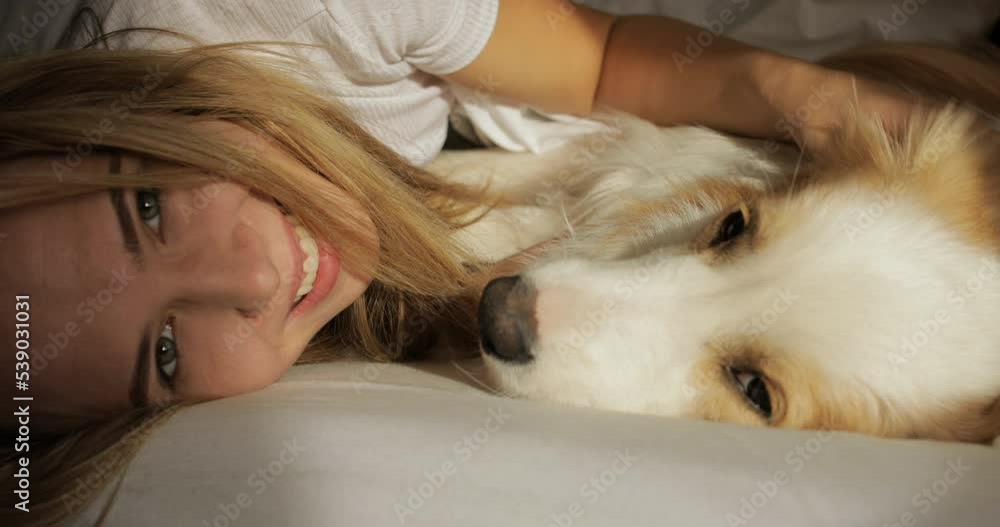 Close up very tender portrait of smiling young women huggin red dog puppy Border Collie in bed. white sheets and tshort. morning light, Prores Close up very tender portrait of smiling young women huggin red dog puppy Border Collie in bed. white sheets and tshort. morning light, Prores