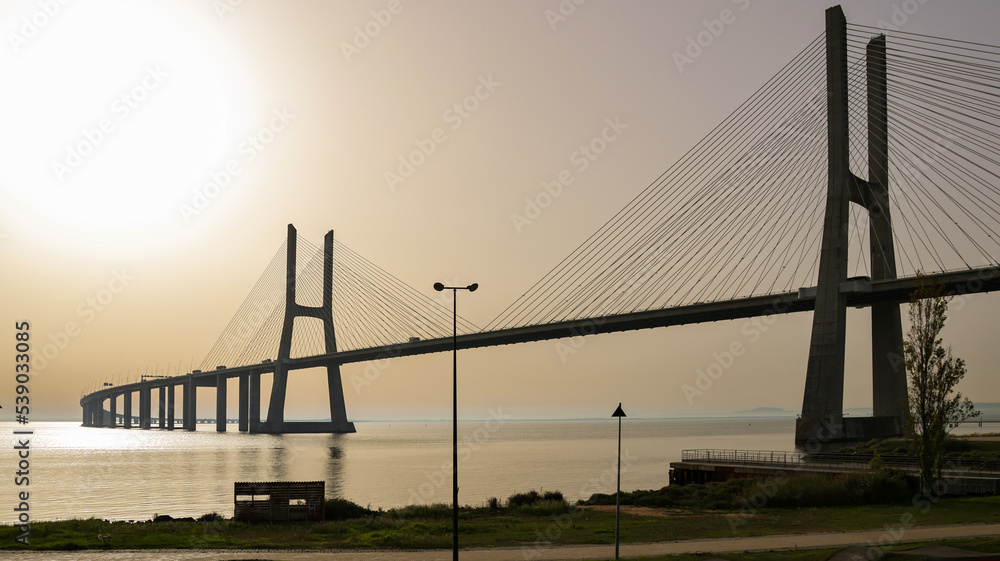 Fototapeta premium Beautiful landscape at sunrise on the Tagus river next to Vasco de Gama bridge in Lisbon, Portugal