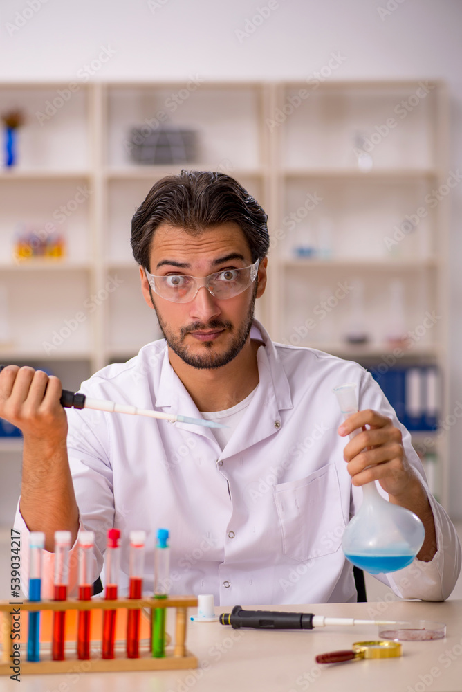 Young male chemist working at the lab Young male chemist working at the lab