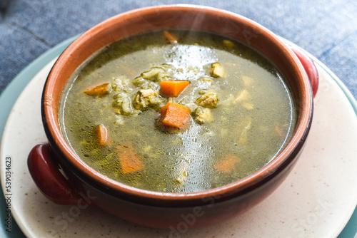 Peruvian food soup with cilantro, carrots and chicken called aguadito.  photo