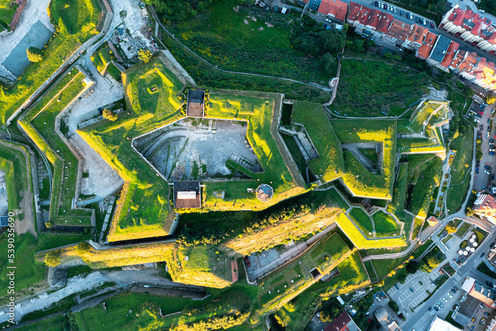 Aerial view of a medieval fortress, panorama of an old fortress covered with green grass at sunset, Poland