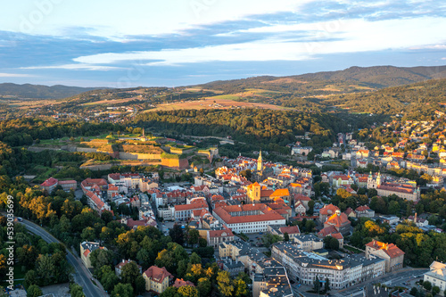 Panorama of the old town of Klodzko from above, beautiful cityscape at sunset and red tiled roofs