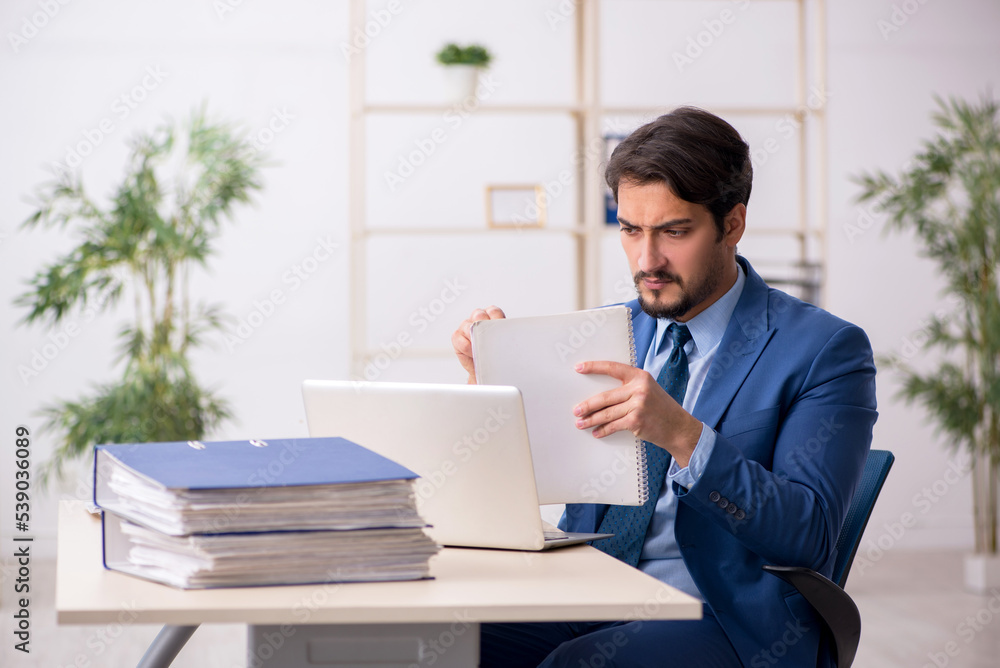 Fototapeta premium Young male employee and too much work in the office