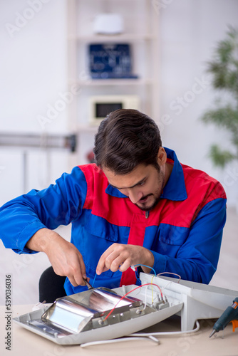 Young male repairman repairing heater