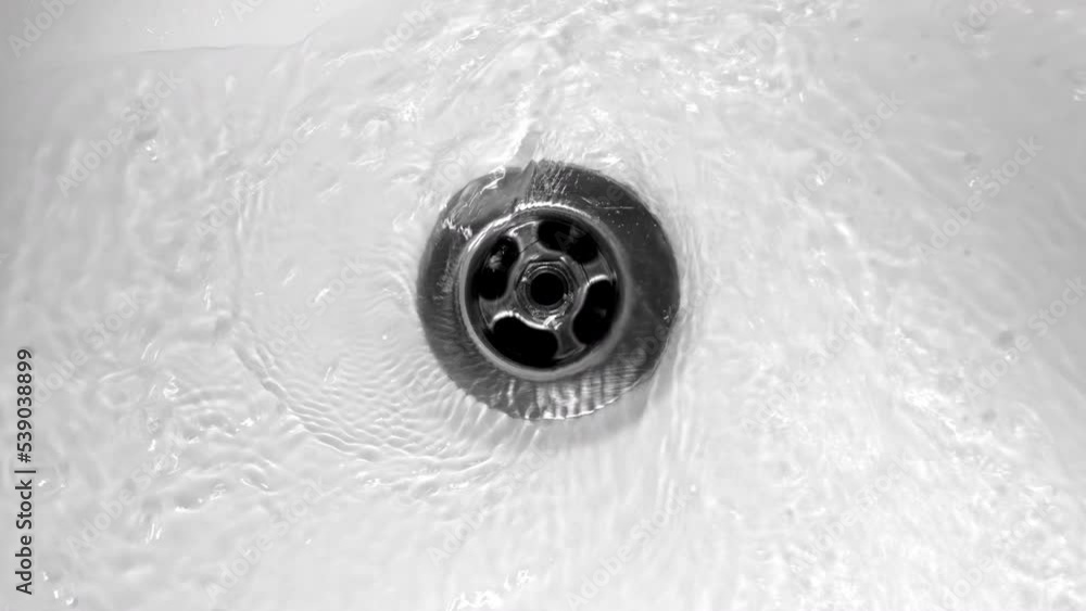 Water flows down in sink drain hole. slow motion water drain in sink