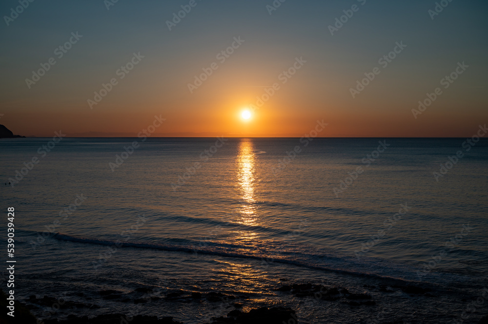 Sunset in calm waters of Atlantic ocean and clear sky Sunset in calm waters of Atlantic ocean and clear sky