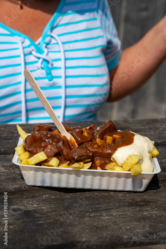 Lunch with traditional street food in Belgium, French fried potatoes with beef stew and mayonnaise photo