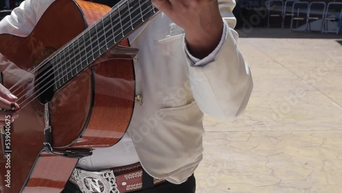 group of mariachi mexican music playing guitar in a public mexican fiesta at a park