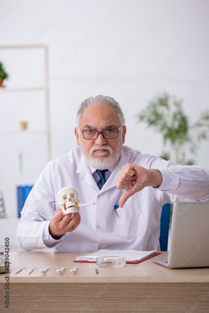 Old male doctor dentist working in the clinic Old male doctor dentist working in the clinic