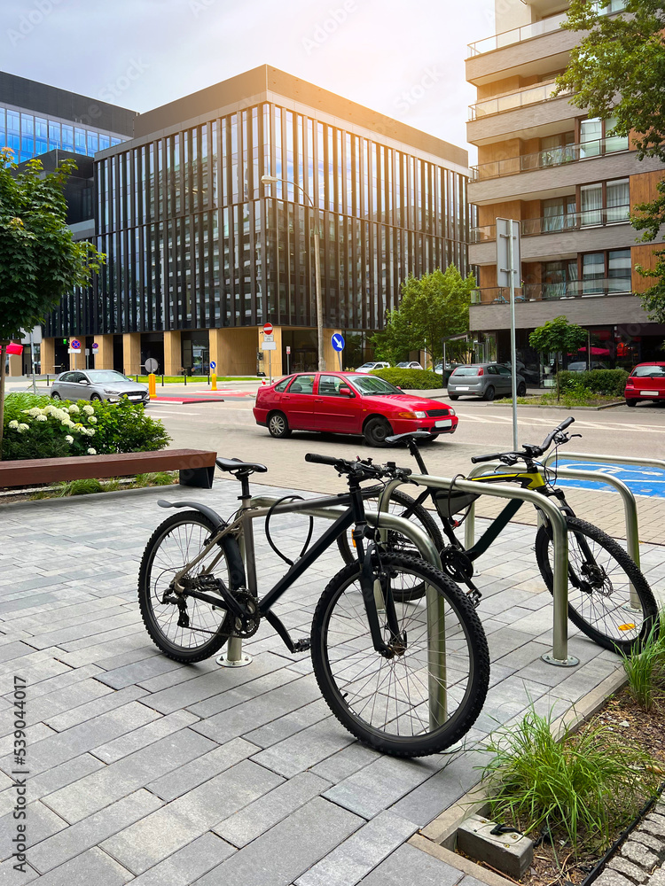 Beautiful view of modern buildings, bicycle stands and cars on city street