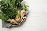 Basket with fresh sugar beets on white wooden table, top view. Space for text