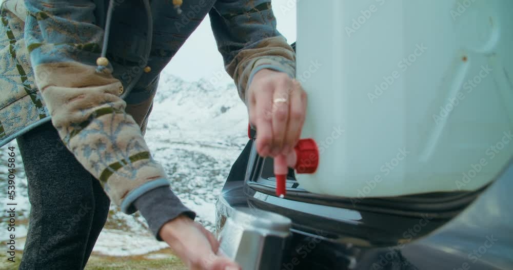 Camping life on mountains road trip. Woman hand closeup pouring drink water into the moka pot coffee maker. Traveler female outdoors makes coffee in stovetop. Camping life on mountains road trip. Woman hand closeup pouring drink water into the moka pot coffee maker. Traveler female outdoors makes coffee in stovetop.