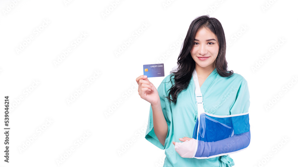 Injured asian woman patient accident broken hand soft splint arm showing mock up credit card standing on white background. Smile young girl hold empty card over isolated.Insurance accident health care Injured asian woman patient accident broken hand soft splint arm showing mock up credit card standing on white background. Smile young girl hold empty card over isolated.Insurance accident health care