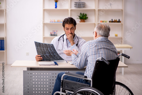 Old injured man visiting young male doctor radiologist