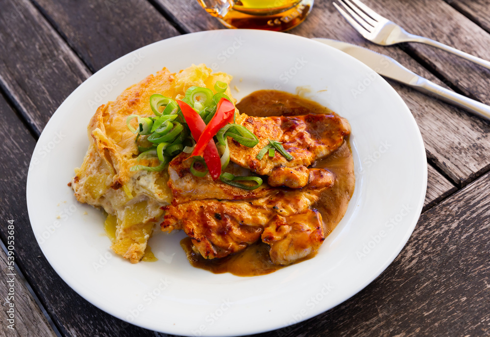 Czech dish - chicken with baked potato served with sauce and greens