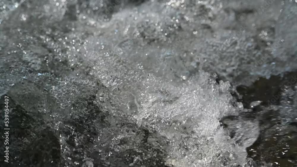Bokeh of water running over rocks in the mountains (slow motion) Bokeh of water running over rocks in the mountains (slow motion)