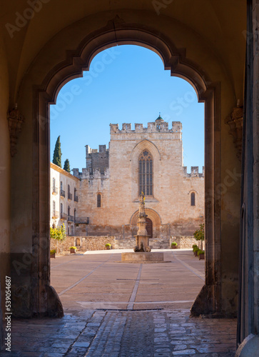 View of church main facade with Gothic stained glass window in courtyard of medieval Santes Creus Monastery, Aiguamurcia, Spain.. © JackF