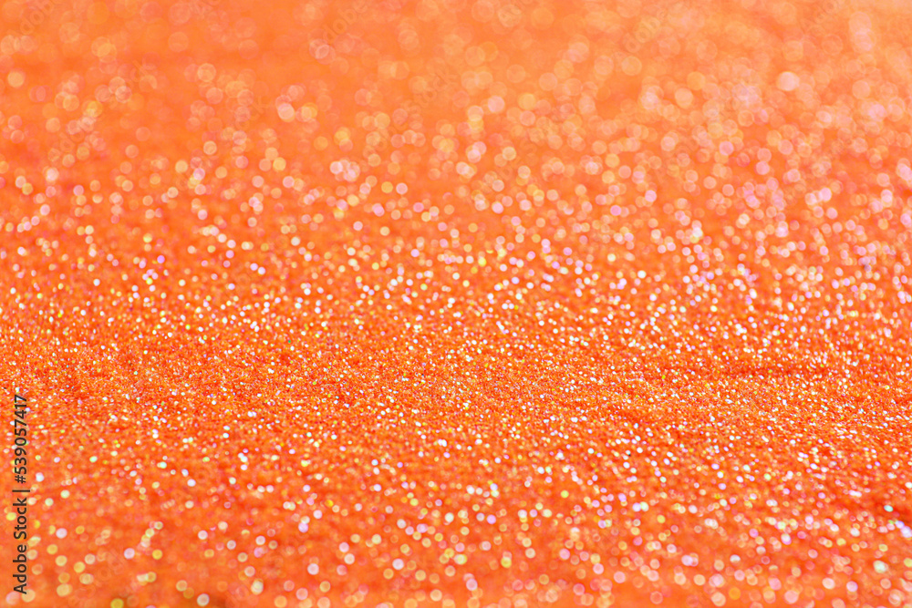 Shiny orange glitter as background, closeup view Shiny orange glitter as background, closeup view