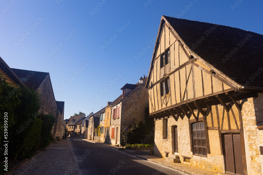 View of typical street in old historic district of Provins town in France on summer day overlooking ancient wooden timber-framed houses