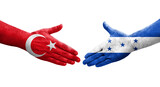 Handshake between Honduras and Turkey flags painted on hands, isolated transparent image.