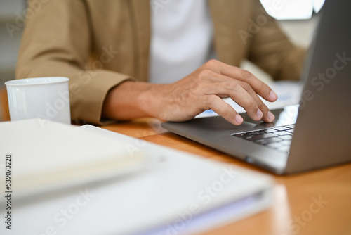 Smart Asian businessman or male CEO working at his desk, typing on laptop keyboard