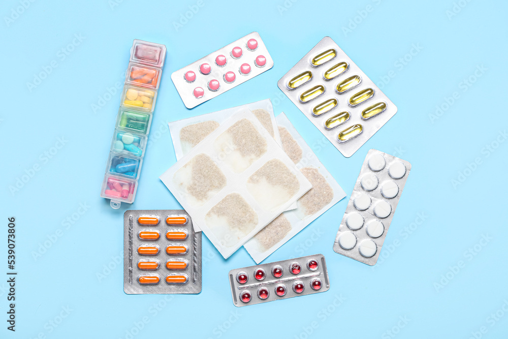 Mustard plasters with pills on blue background Mustard plasters with pills on blue background