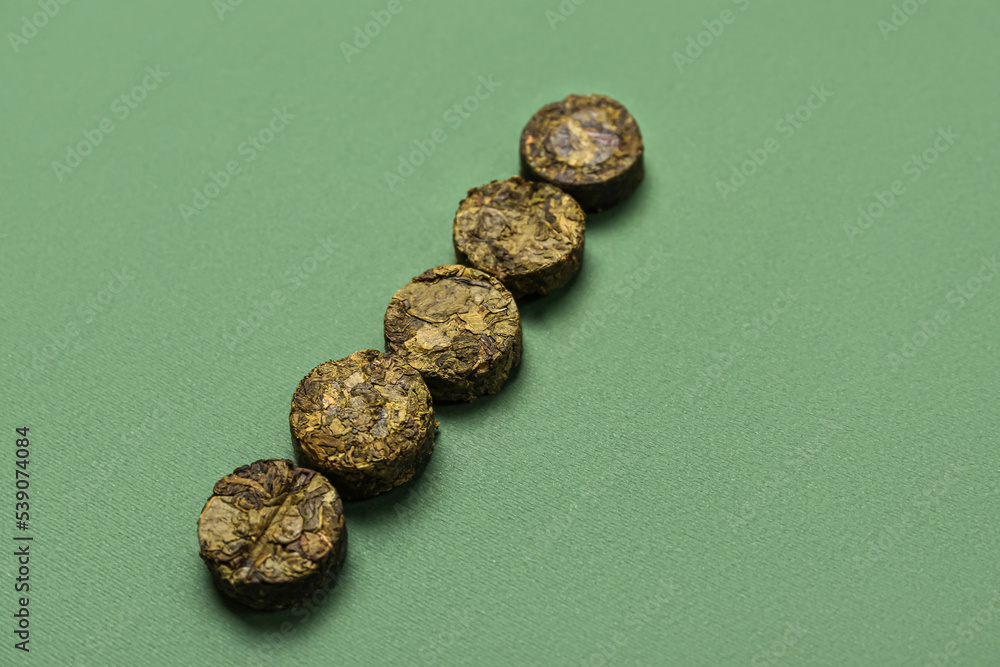 Dry pressed puer tea on green background Dry pressed puer tea on green background