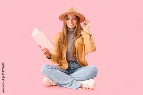 Young woman with book sitti...