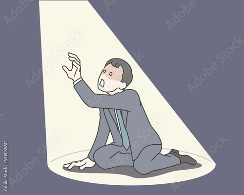 絶望の表情でスポットライトに照らされ天を仰ぐスーツの男性