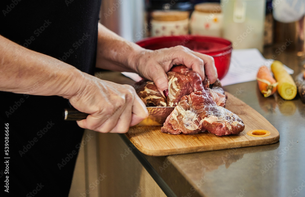 Chef cuts the beef with knife and prepares it for baking in the oven