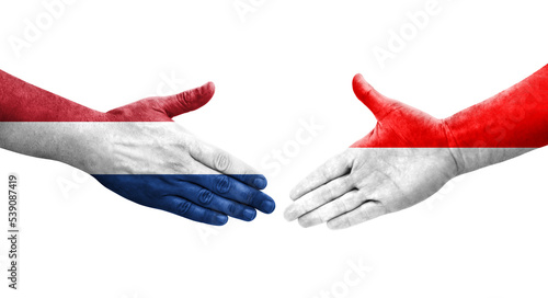Картината върху платно Handshake between Indonesia and Netherlands flags painted on hands, isolated transparent image