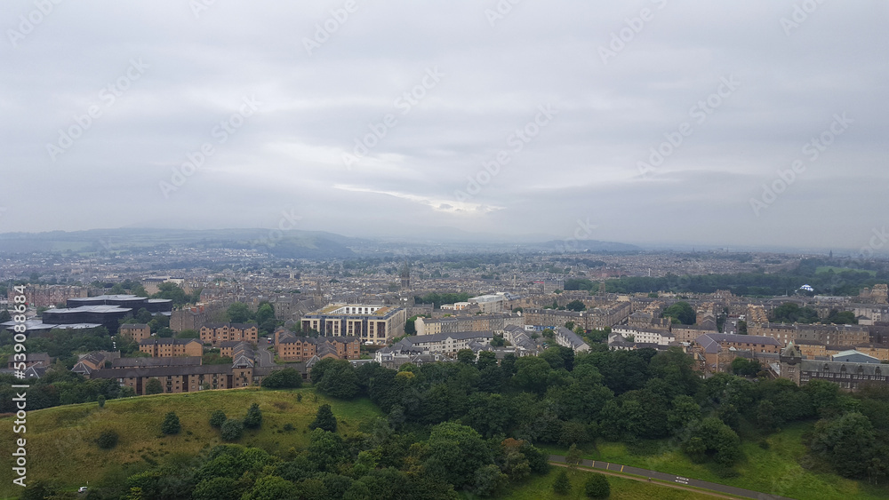 A sprawling landscape view of Edinburgh city from popular Scottish walkway of Arthur's Seat in Scotland