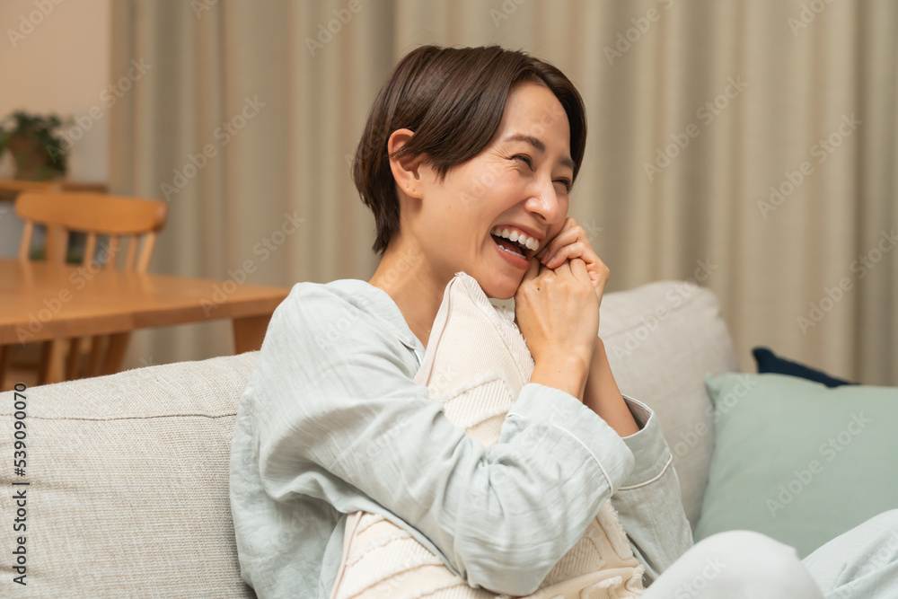 ソファで笑顔のパジャマ姿の日本人女性 ソファで笑顔のパジャマ姿の日本人女性