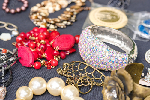 Retro style bracelets and necklaces. Vintage old-fashioned jewelry at flea market stall or car boot sale. Vintage goods for sale. Garage sale concept. Selective focus