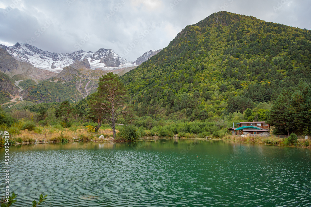 Mountain landscape with a glacier in the distance. Lake in the mountains. Tana glacier in Ossetia.