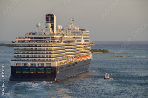 Modern HAL cruiseship or cruise ship liner Koningsdam sail away departure from port during Caribbean cruising dream vacation twilight blue hour sunset seascape landscape scenery photo