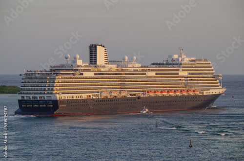 Modern HAL cruiseship or cruise ship liner Koningsdam sail away departure from port during Caribbean cruising dream vacation twilight blue hour sunset seascape landscape scenery