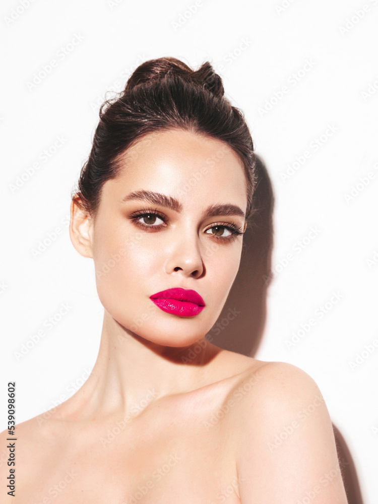 Fashion beauty portrait of young brunette woman with evening stylish makeup and perfect clean skin. Sexy model with hair in a bun posing in studio. With pink bright natural lips. Isolated on white Fashion beauty portrait of young brunette woman with evening stylish makeup and perfect clean skin. Sexy model with hair in a bun posing in studio. With pink bright natural lips. Isolated on white